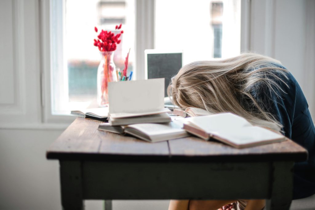 A tired and confused female student leaning on table