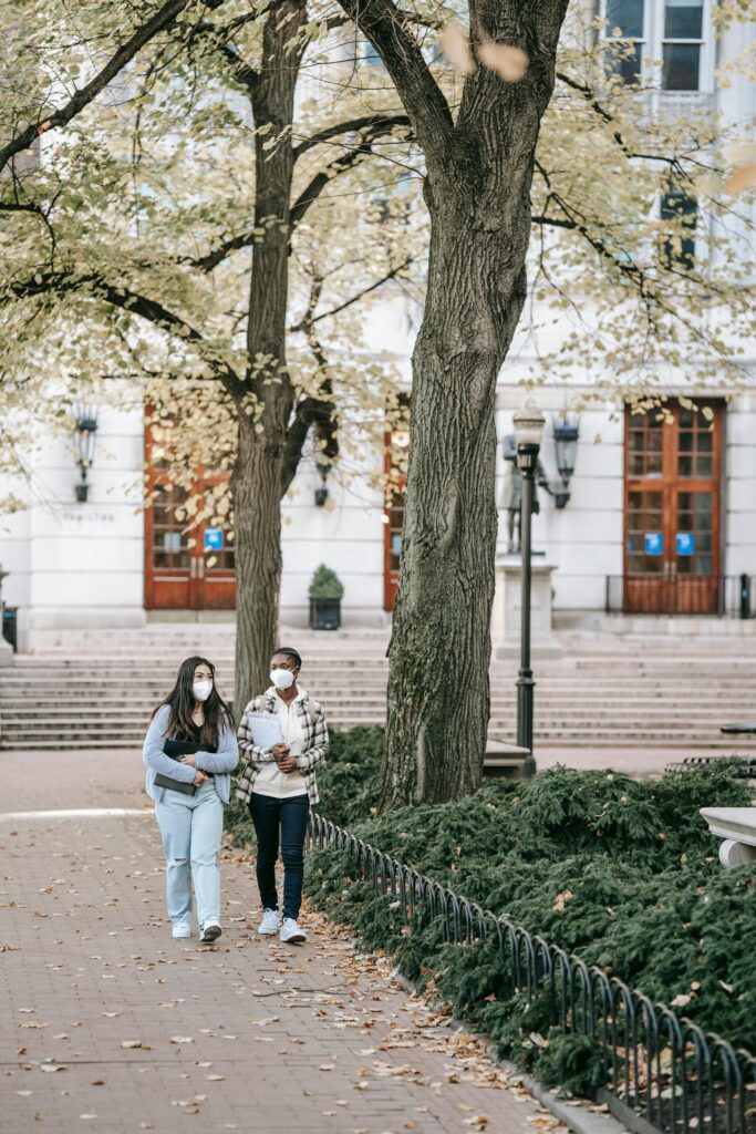 Two female healthcare students walking in university park together