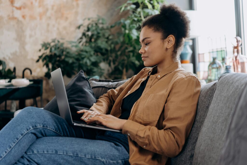 A lady taking an online course on her laptop while sitting in her room