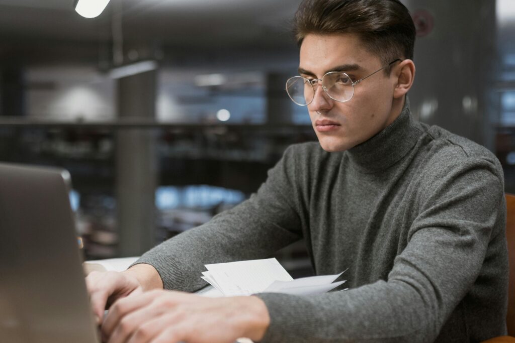 A guy on glasses working on his computer