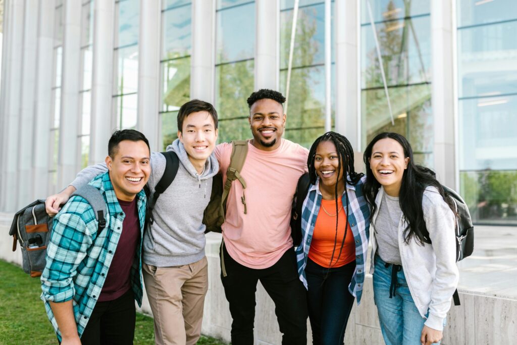 Group of college students standing and taking pictures while smiling